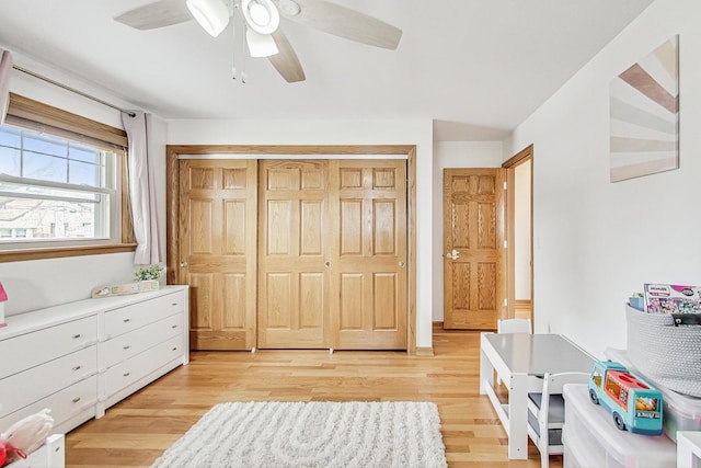 bedroom featuring light wood-type flooring, ceiling fan, and a closet