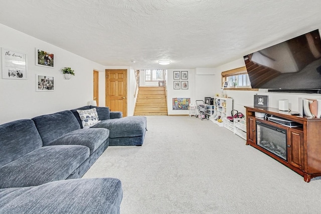 living room with light colored carpet, a textured ceiling, and a wealth of natural light