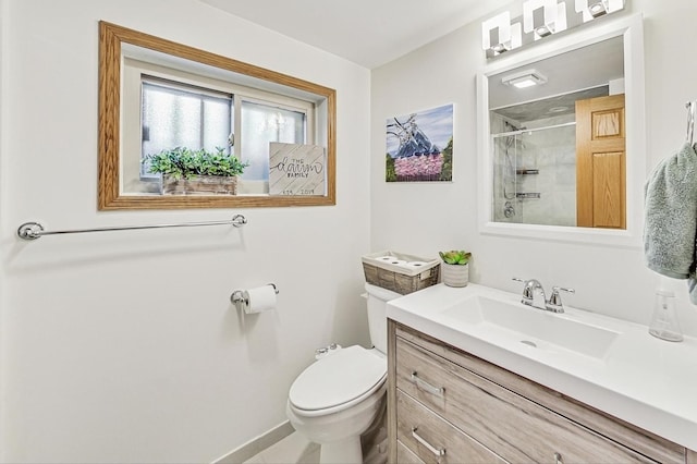 bathroom with vanity, toilet, and a tile shower