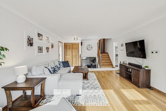 living room with crown molding and light hardwood / wood-style flooring