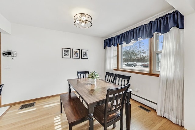 dining space with hardwood / wood-style floors and a baseboard radiator