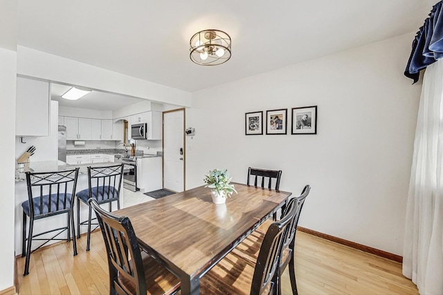 dining room featuring sink and light wood-type flooring