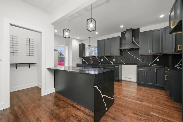 kitchen with sink, hanging light fixtures, dark hardwood / wood-style floors, wall chimney range hood, and backsplash