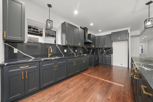 kitchen featuring wall chimney exhaust hood, gray cabinets, and sink