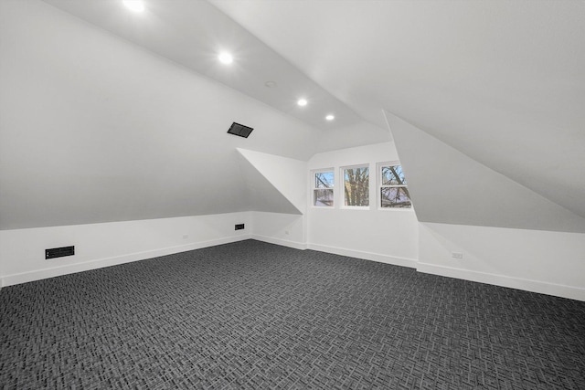 additional living space with lofted ceiling and dark carpet