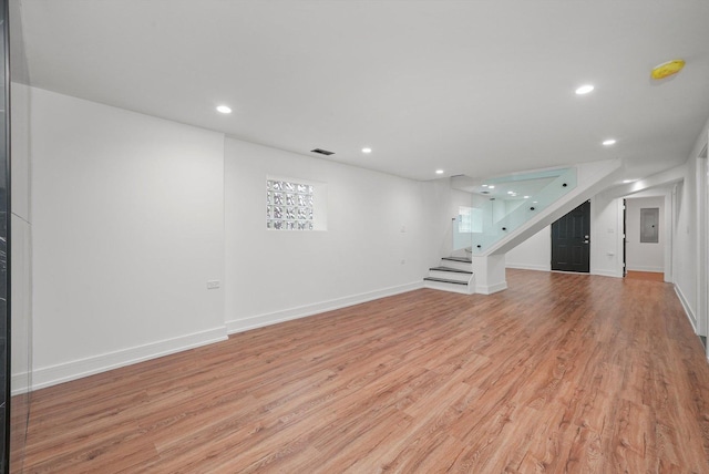 unfurnished living room with electric panel and light wood-type flooring