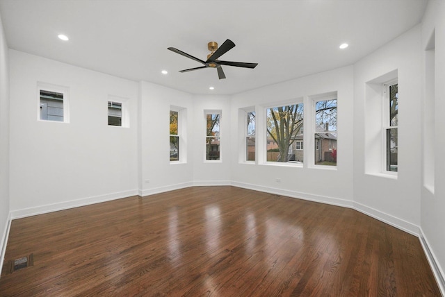 unfurnished room with dark hardwood / wood-style flooring, plenty of natural light, and ceiling fan