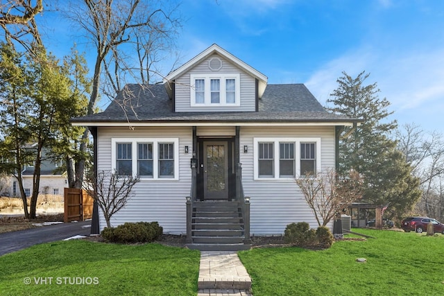 view of front of home featuring cooling unit and a front lawn