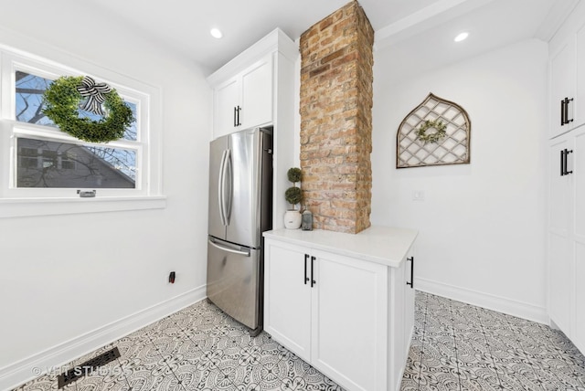 kitchen featuring white cabinetry, light tile patterned floors, and stainless steel refrigerator