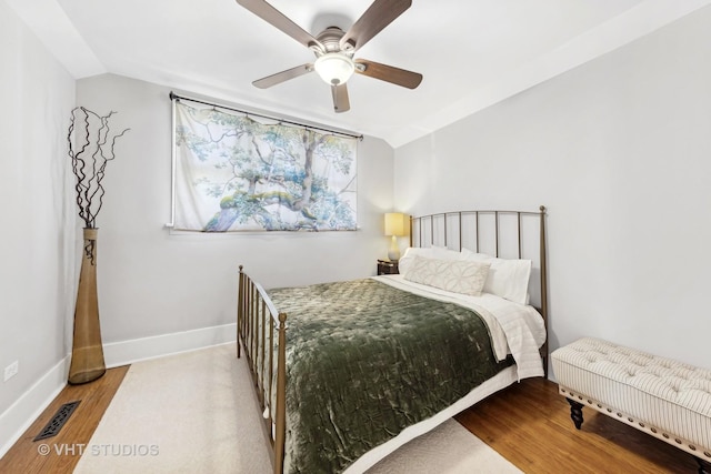 bedroom with ceiling fan, vaulted ceiling, and light hardwood / wood-style flooring