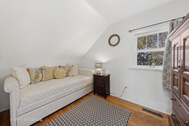 bedroom with vaulted ceiling and hardwood / wood-style floors