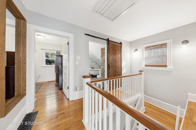 corridor with hardwood / wood-style flooring and a barn door