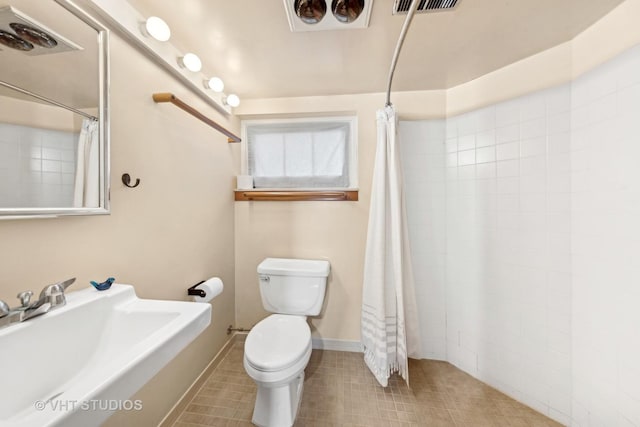 bathroom with a shower with curtain, sink, and toilet