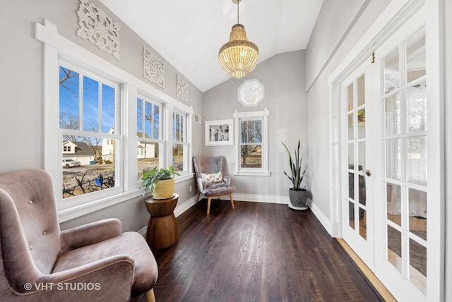 living area with dark hardwood / wood-style flooring, vaulted ceiling, and a chandelier