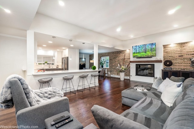 living room featuring dark wood-type flooring and brick wall