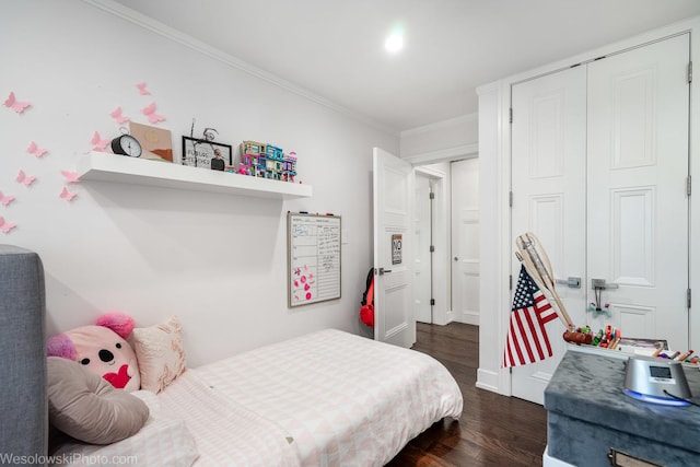 bedroom with ornamental molding, dark hardwood / wood-style flooring, and a closet