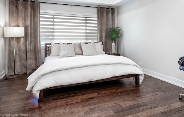 bedroom with dark hardwood / wood-style flooring