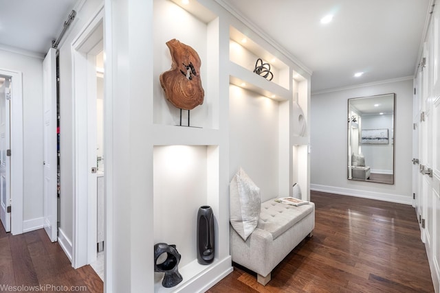 interior space featuring ornamental molding, a barn door, and dark wood-type flooring