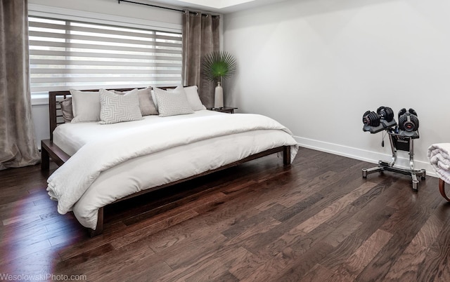 bedroom featuring dark hardwood / wood-style flooring and multiple windows