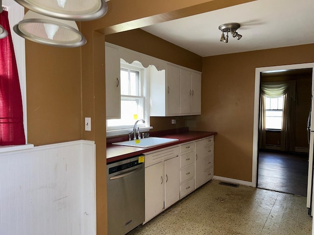 kitchen with sink, stainless steel dishwasher, and white cabinets