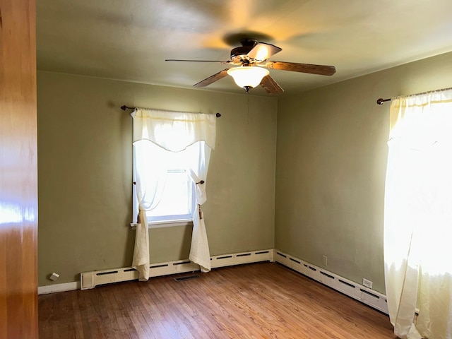 empty room featuring hardwood / wood-style floors, a healthy amount of sunlight, and ceiling fan