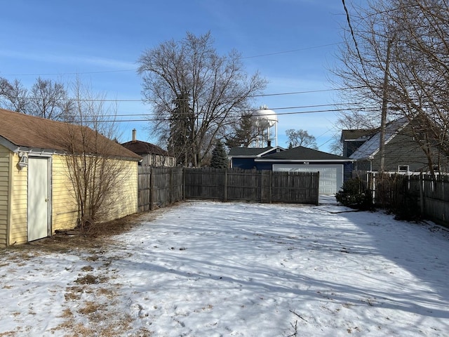 yard layered in snow featuring a garage