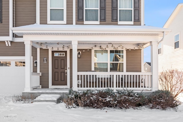 snow covered property entrance featuring a garage