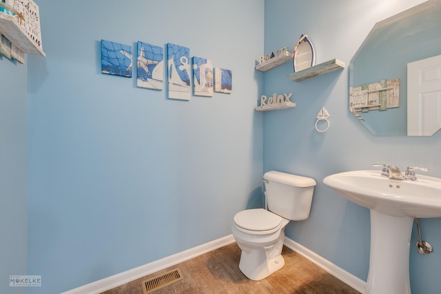 bathroom with sink, hardwood / wood-style floors, and toilet