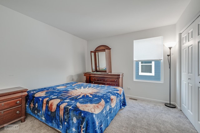 bedroom featuring light colored carpet and a closet