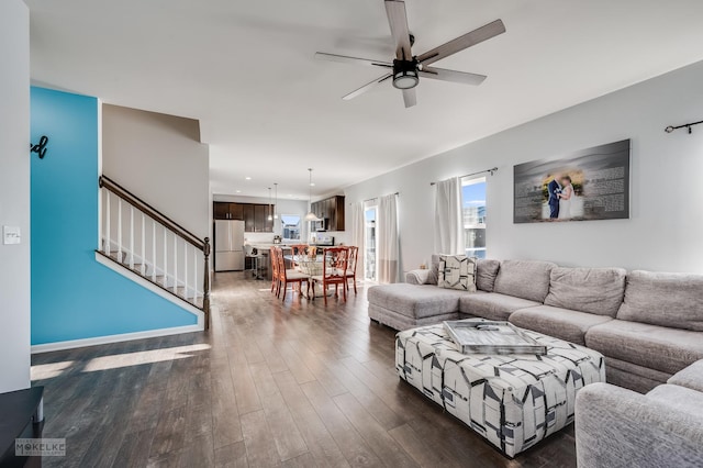 living room with ceiling fan and dark hardwood / wood-style flooring