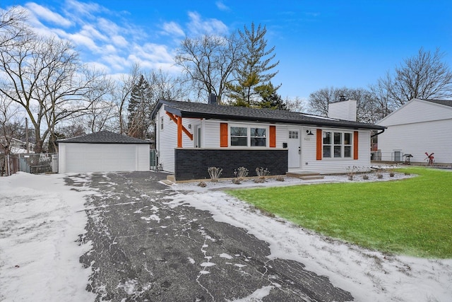 ranch-style house with a garage, an outdoor structure, and a lawn