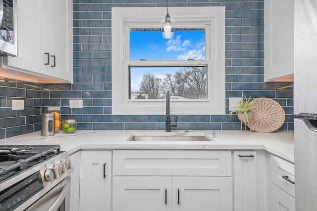 kitchen featuring white cabinetry, appliances with stainless steel finishes, sink, and decorative backsplash