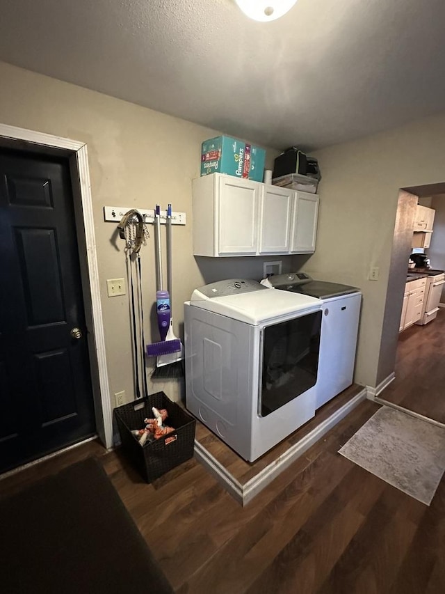 laundry room with dark wood-type flooring, baseboards, cabinet space, and washing machine and clothes dryer