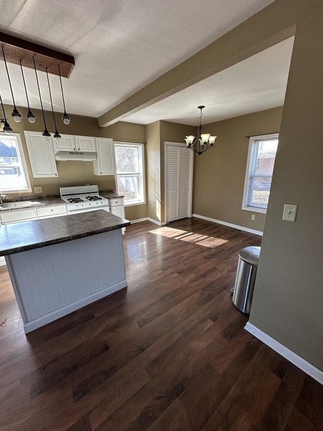 kitchen with dark wood-type flooring, a sink, baseboards, white cabinets, and white range with gas cooktop