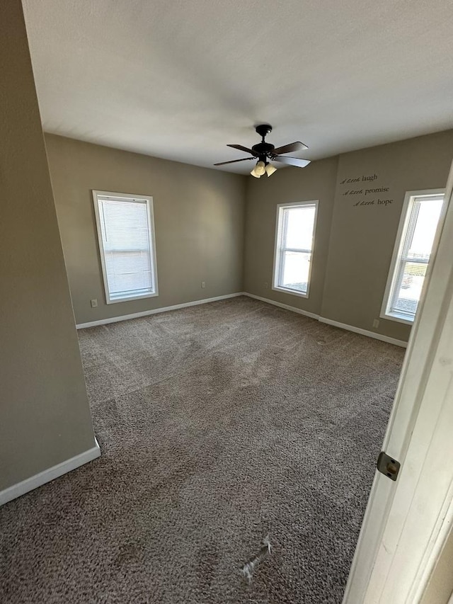 spare room featuring ceiling fan, a textured ceiling, carpet, and baseboards