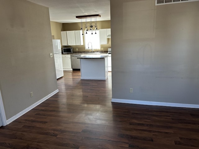 kitchen featuring stainless steel appliances, white cabinets, a sink, and baseboards