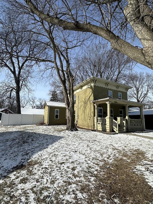 view of front of property with a porch and fence