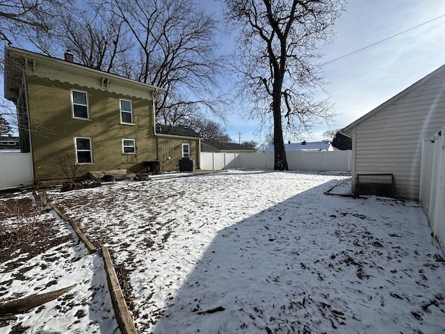 yard covered in snow featuring fence