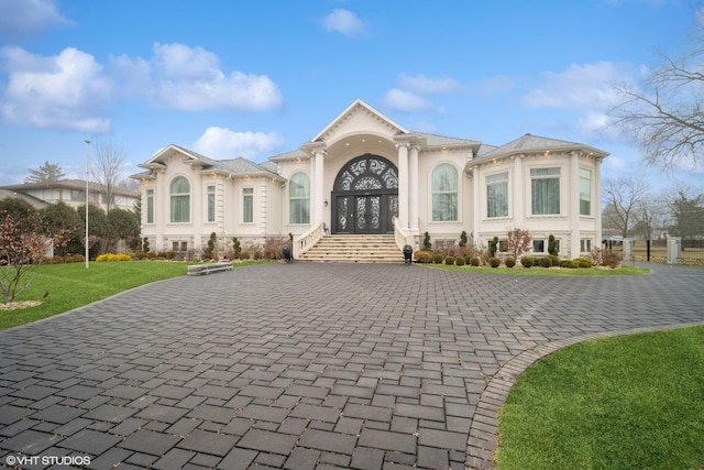 mediterranean / spanish home featuring a front lawn and french doors