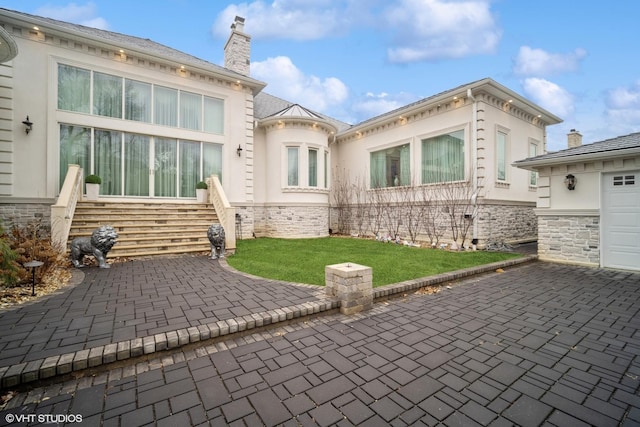 back of house with a garage and a yard