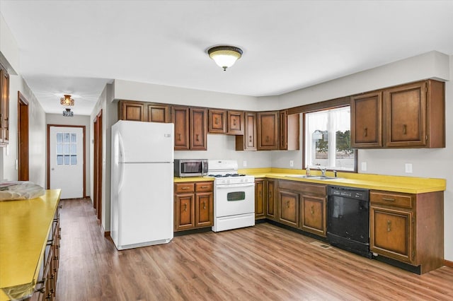 kitchen with sink, white appliances, and light wood-type flooring