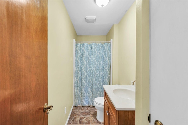 bathroom featuring vanity, walk in shower, and toilet