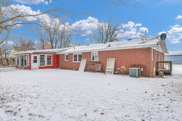 snow covered house with central AC unit