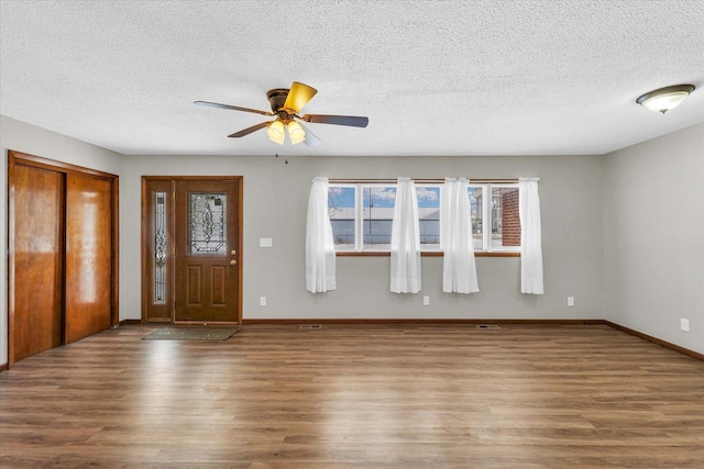 foyer entrance featuring hardwood / wood-style flooring, ceiling fan, and a textured ceiling