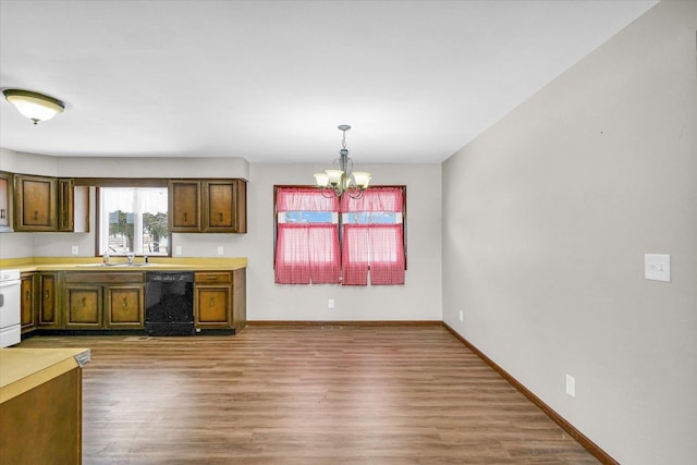 kitchen with range, decorative light fixtures, a chandelier, black dishwasher, and hardwood / wood-style flooring