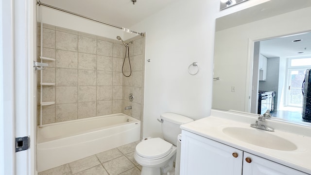 full bathroom with tiled shower / bath, toilet, tile patterned floors, and vanity