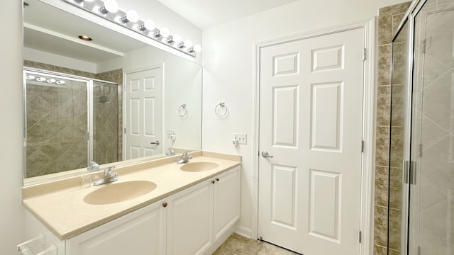 bathroom featuring tile patterned floors, a shower with door, and vanity