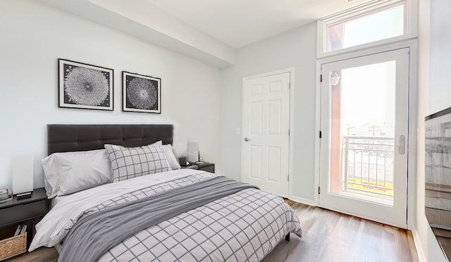 bedroom with access to outside and light wood-type flooring