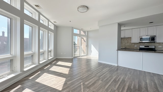 kitchen featuring white cabinetry, appliances with stainless steel finishes, a healthy amount of sunlight, and decorative backsplash