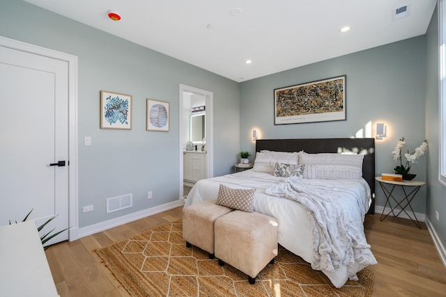 bedroom featuring hardwood / wood-style flooring and ensuite bath